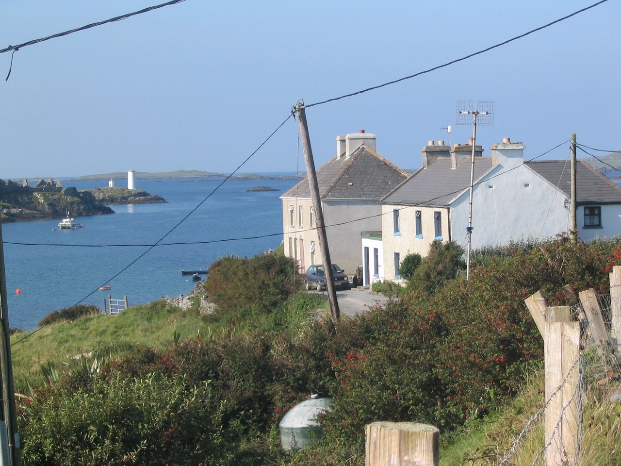 Looking across Inishbofin Harbour towards the white navigation marker which marks the harbour entrance and to its left Cromwell's Fort.