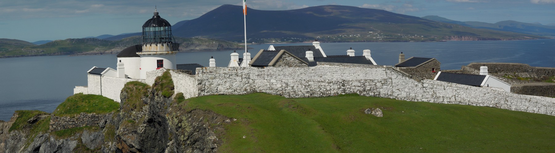 Clare Island Lighthouse with Achill in the background - such buildings became unnecessary for the operation of a lighthouse and were sold