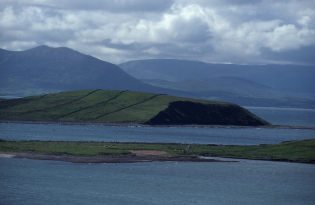 The end (in shadow) of the drumlin island has been cut off cleanly by the sea and the island will eventually be eroded completely. Clew Bay islands are mostly drumlins which are typically long rounded hills deposited at the end of the last Ice Age.