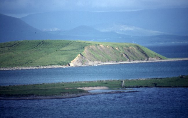 The end of this drumlin island has been cut off cleanly by the sea and the island will eventually be eroded completely. Clew Bay islands are mostly drumlins which are typically long rounded hills deposited at the end of the last Ice Age.