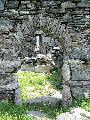 The doorway of the ruined church with Leac na Naomh in view
